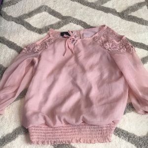 A light pink really thin cold shoulder top